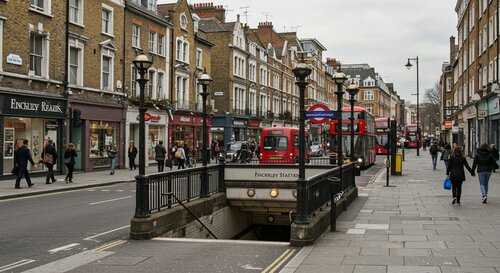 Finchley Road area showing Underground station entrance with typical London architecture, cafes, and tree-lined streets in North London